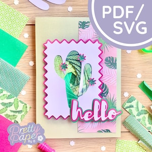 May include: A green and pink layered paper craft card with a cactus silhouette and the word "hello" in pink and green letters. The card is surrounded by green and pink patterned paper scraps.