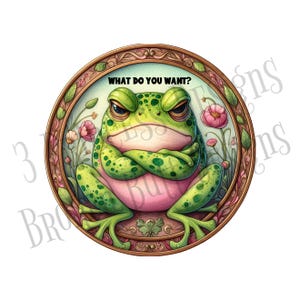 May include: A round, decorative image featuring a grumpy green frog with arms crossed, set within a floral frame. The frog has a pink belly and is surrounded by pink flowers. The text "WHAT DO YOU WANT?" is above the frog.