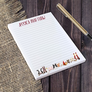 May include: A white notepad with red lined paper and a border of cartoon farm animals. The notepad has the name "Jessica Matthew" printed at the top.