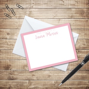 May include: A pink and white stationery card with a pink border and the text "From the desk of Laura Morris".