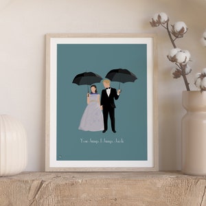 May include: A framed print with a blue background featuring a couple standing under two black umbrellas. The text "You can always, always, come back" is printed below the couple.