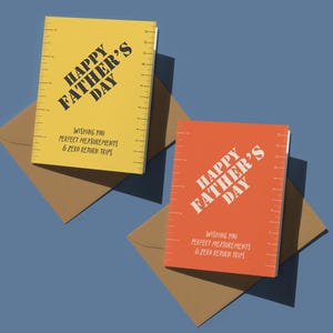 May include: Two Father's Day cards with brown envelopes on a blue background. One card is yellow, the other is orange. Both cards have the text "HAPPY FATHER'S DAY" and "WISHING YOU PERFECT MEASUREMENTS & ZERO RETURN TRIPS".