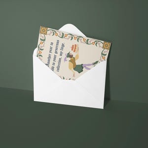 May include: A white envelope with a colorful card inside. The card has a floral border and a picture of a person holding a cake. The text on the card reads "Another year to add to your generous collection, my liege."