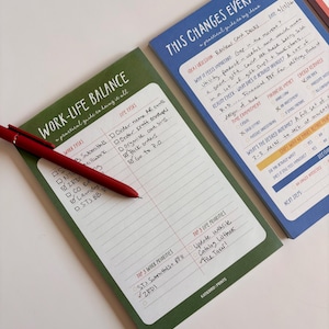 May include: A collection of colorful notepads with handwritten notes and a red pen. The green notepad reads "WORK-LIFE BALANCE" and the blue notepad says "THIS CHANGES EVERYTHING". The notepads are designed for planning and organization.