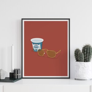 Puede incluir: Un p&oacute;ster minimalista con fondo rojo que presenta un envase de yogur azul y unas gafas de sol aviador marrones.