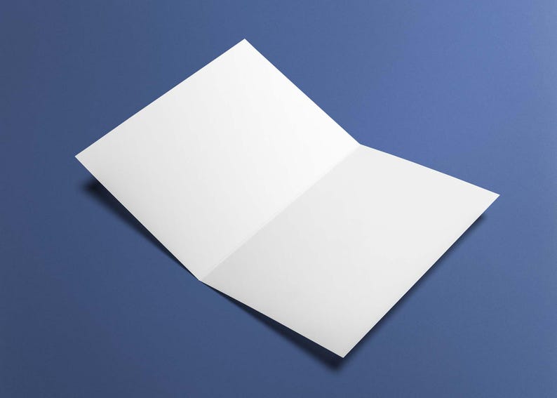 May include: A blank, open greeting card with a white interior, resting on a blue surface. The card is slightly angled, showcasing its unfolded design. The background is a solid, deep blue.