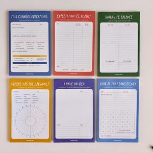 May include: A set of six colorful notepads with various titles and layouts. The titles include "This Changes Everything," "Expectation vs. Reality," and "Work-Life Balance." Each notepad has a different color border and contains lines and prompts for writing.