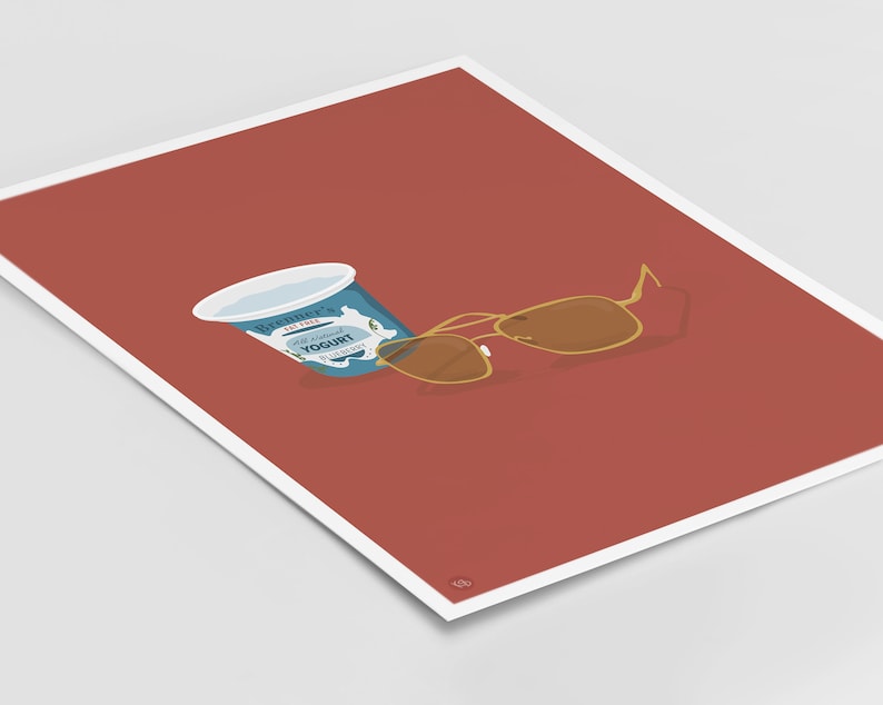 Puede incluir: Un recipiente azul y blanco de yogur natural sobre un fondo rojo con unas gafas de sol aviador doradas.
