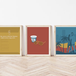 May include: Three framed prints with a minimalist design. The first print is a yellow envelope with the text "My name is Michael Westen. I used to be a spy until..." The second print is a red background with a blue cup and brown sunglasses. The third print is a blue background with a silhouette of a couple walking on a beach with palm trees.
