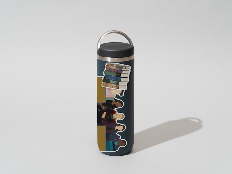 May include: A dark blue stainless steel water bottle with a black lid and a carrying handle. The bottle has a sticker on it featuring a group of people and a stack of books.