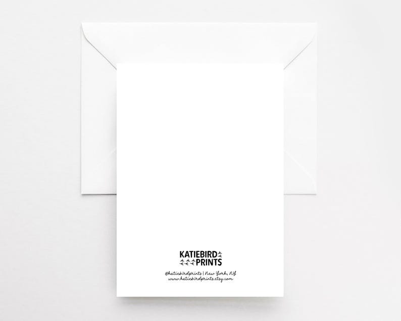 May include: A white greeting card with a matching envelope. The card has the text "KATIEBIRD PRINTS" and contact information printed in black at the bottom. The background is a solid white.