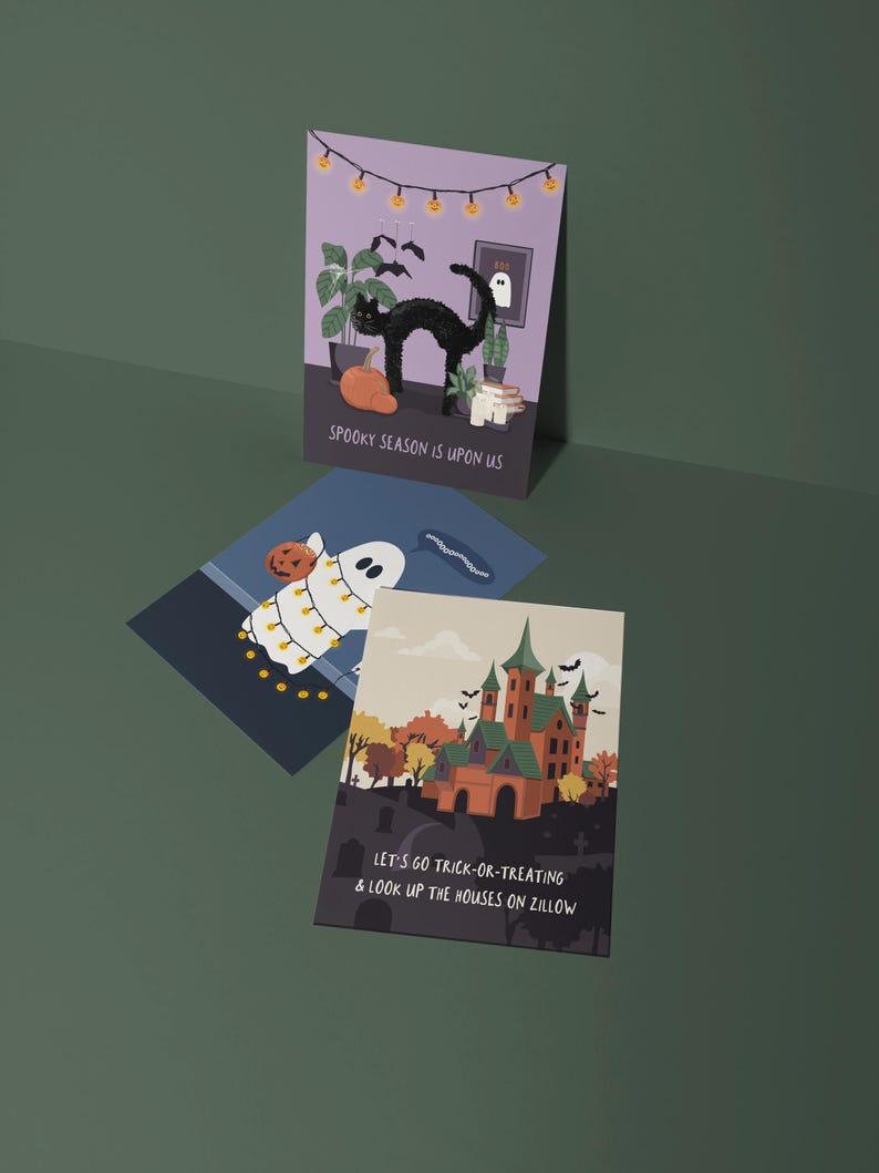 May include: Three Halloween-themed greeting cards. One card features a black cat, pumpkin, and the text "SPOOKY SEASON IS UPON US." Another shows a ghost with a pumpkin and string lights. The third card displays a haunted house and the text "LET'S GO TRICK-OR-TREATING & LOOK UP THE HOUSES ON ZILLOW."
