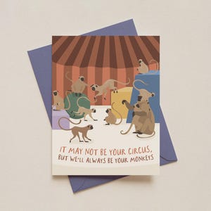 May include: Greeting card with a circus theme. The card features illustrations of monkeys in a circus setting with a red and brown striped backdrop. The text on the card reads: "IT MAY NOT BE YOUR CIRCUS, BUT WE'LL ALWAYS BE YOUR MONKEYS."