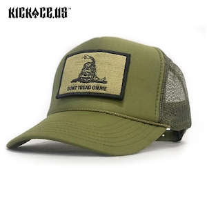 Puede incluir: Gorra de camionero verde oliva con parte trasera de malla negra y visera curva. La parte delantera presenta un parche rectangular con una serpiente enrollada y el texto "DON'T TREAD ON ME". El sombrero tiene el texto "KICKACE.US" en la parte superior izquierda.