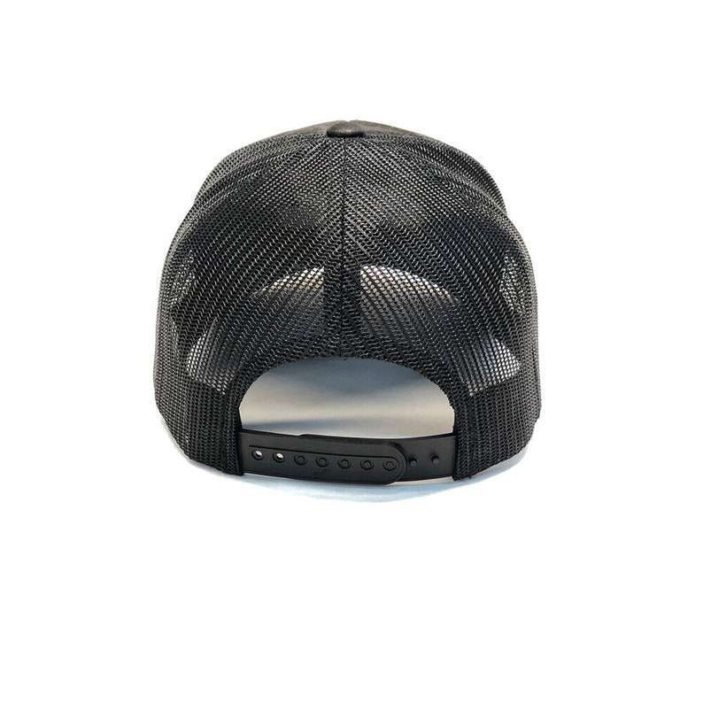 May include: Black mesh trucker hat with a black strap and adjustable buckle closure.