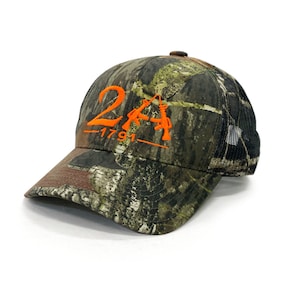 May include: A camouflage trucker hat with an orange embroidered design that says "2A -1791-" with two stylized rifles.