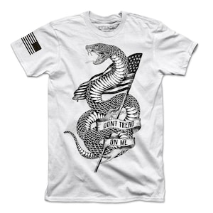 May include: White t-shirt featuring a black and white illustration of a snake wrapped around a flagpole with an American flag. The snake has the words "Don't Tread On Me" written on a banner.