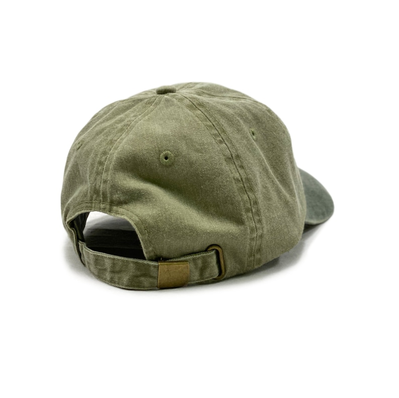 May include: A green cotton baseball cap with a brown adjustable strap. The cap is viewed from the back.