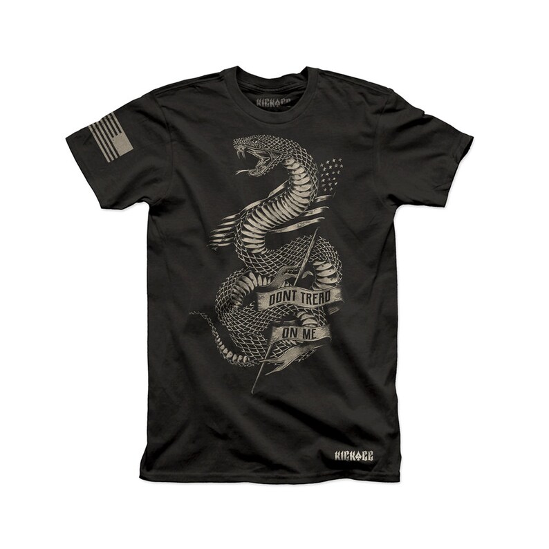 May include: Black t-shirt featuring a graphic of a snake wrapped around a spear with the text "Don't Tread On Me". The snake is in a vintage style and the text is in a banner.