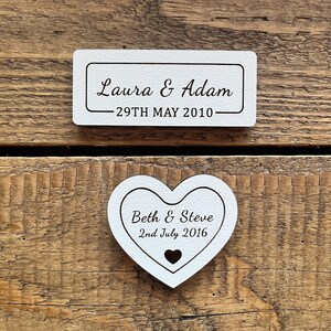 Off-white wooden personalised plaques which can be displayed alongside framed flowers, featuring names and date