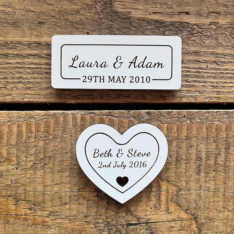 Off-white wooden personalised plaques which can be displayed alongside framed flowers, featuring names and date