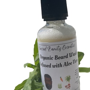 May include: A clear glass bottle with a black dropper top filled with a white liquid. The bottle has a white label that reads "Blessed Beauty Cosmetics Organic Beard Wash Infused with Aloe Vera" and "8 FL OZ".