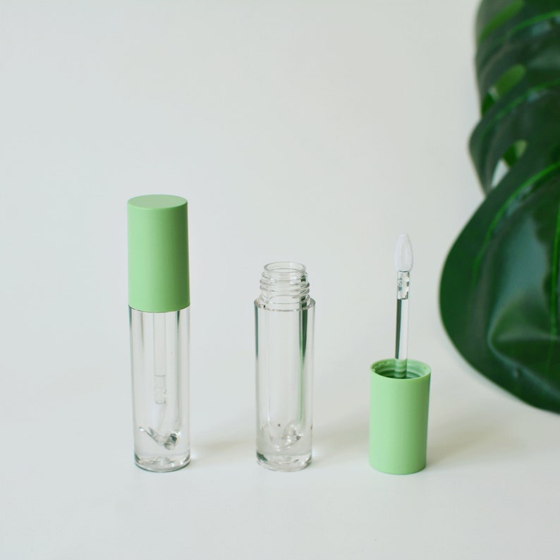 May include: Three clear lip gloss tubes with green caps. The tubes are empty and ready to be filled with lip gloss.