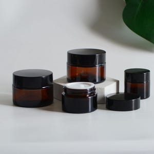 Barattolo di vetro ambrato trasparente da 5 g, 15 g, 30 g, 50 g, tappo nero per balsamo per il corpo cosmetico, scrub per il corpo, crema per gli occhi, ordine all'ingrosso