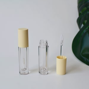 May include: Three clear lip gloss tubes with yellow caps. The tubes are empty and have a clear applicator wand.