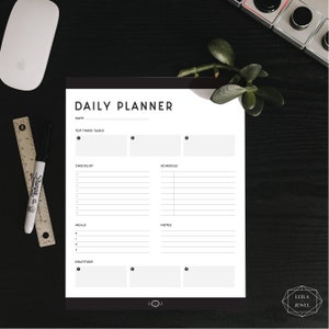 May include: A black and white daily planner with sections for top three tasks, checklist, schedule, meals, notes, and gratitude. The planner has a simple design with a black header and white text.