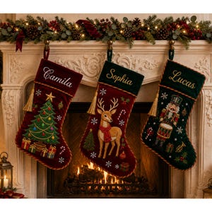 Puede incluir: Tres calcetines navideños de terciopelo colgados. El primero es rojo con el nombre Camila, un árbol de Navidad y regalos. El segundo es rojo con el nombre Sophia y un reno. El tercero es verde con el nombre Lucas y un cascanueces.