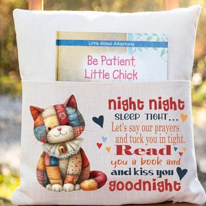 May include: A white pillow with a pocket, featuring a colorful patchwork cat illustration. The pillow has text that reads "night night, sleep tight... Read you a book and kiss you goodnight." A children's book is in the pocket.