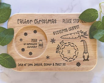 May include: A wooden serving tray with a Christmas theme. It has a place for milk, a mince pie, a carrot, and a gnome. The text on the tray reads "Father Christmas Please Stop Here, Milk or something stronger, Rudolph's Carrot, Mince Pie, Lots of Love Joshua, Oliver & Molly xx".