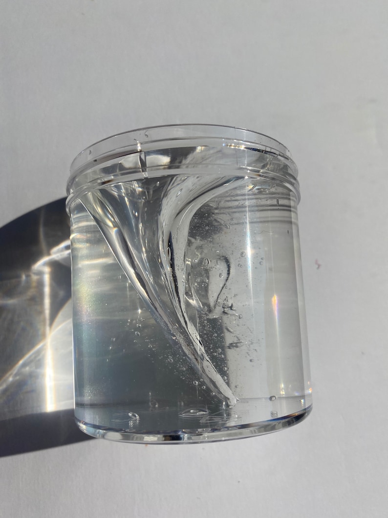 May include: A clear plastic container filled with a clear, viscous liquid that is swirling in a vortex pattern.