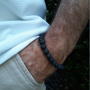 May include: A black beaded bracelet made of lava rock.