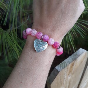 May include: Pink and white agate bead bracelet with a silver heart charm that reads "You are always in my heart".