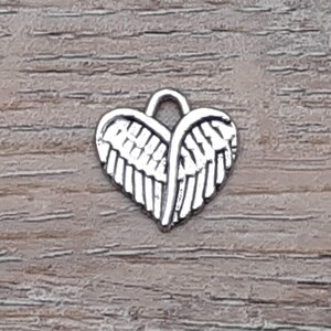 Puede incluir: Encanto de plata en forma de coraz&oacute;n con alas de &aacute;ngel.