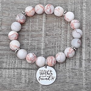 May include: A bracelet made of white and pink marbled stones with silver accents. The bracelet has a charm that says "Always my mother forever my friend".