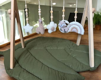 Gimnasio de madera para bebés hecho a mano con juguetes sensoriales de bouclé y tapete de juego con hojas