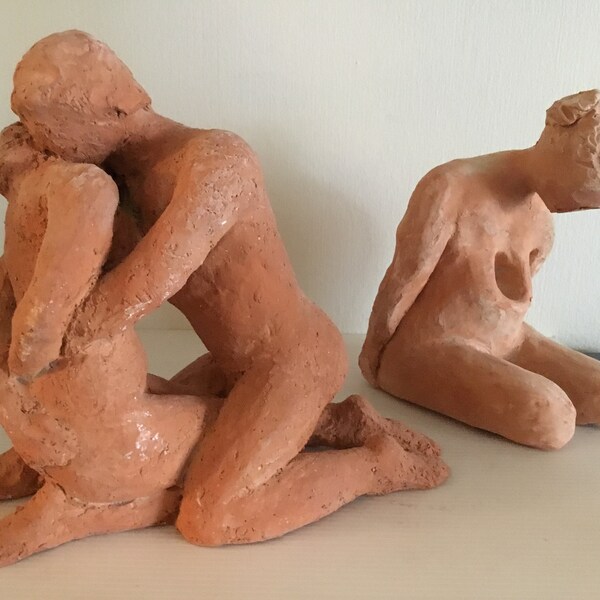 2 statues en plâtre rouille : couple enlacé et femme enceinte