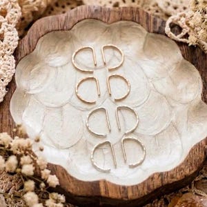 May include: A handmade wooden sign with the text "Welcome to our home" in a handwritten style. The sign is painted white with black lettering and a distressed finish, perfect for home decor.