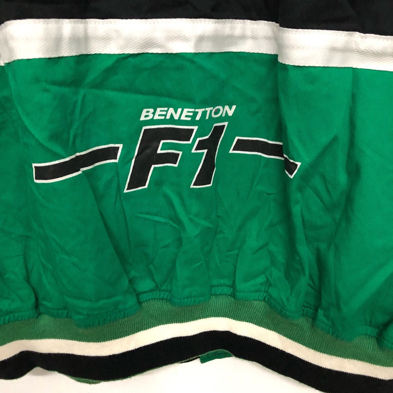 May include: Green and black jacket with a white stripe and the text "BENETTON -F1- "