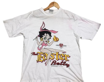 May include: White t-shirt with a cartoon image of Betty Boop dressed as an Easter bunny. The text "The Easter Betty" is printed below the image.
