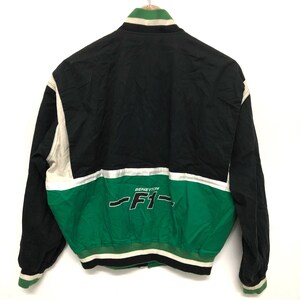 May include: Black, white, and green jacket with a Benetton F1 logo on the back.