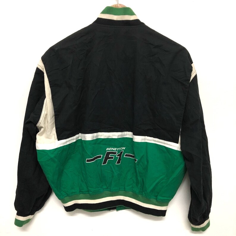 May include: Black, white, and green jacket with a Benetton F1 logo on the back.