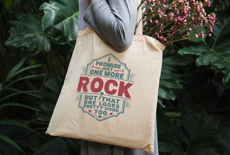 May include: A beige canvas tote bag with a vintage-style design featuring the text "I promise just one more rock but that one looks pretty good too".