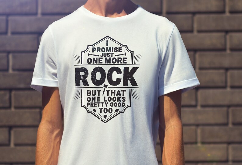 May include: White t-shirt with a black graphic design that says "I promise just one more rock but that one looks pretty good too".