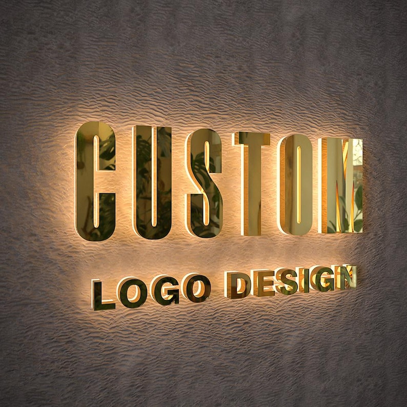 May include: Gold-colored, illuminated sign on a textured wall. The sign reads "CUSTOM" above "LOGO DESIGN" in a matching font. The letters have a reflective, metallic appearance, and the background is a neutral color.