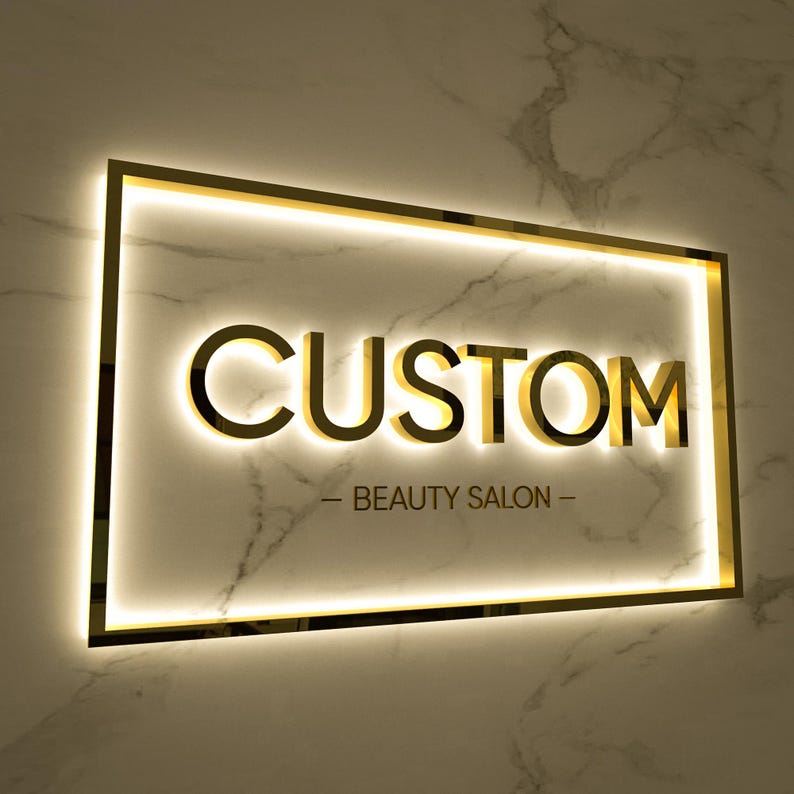 May include: A gold-colored sign with the word "CUSTOM" in raised letters and the text "BEAUTY SALON" below it. The sign is illuminated with white lights.