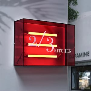May include: A red acrylic box with a neon sign that reads "2/3 KITCHEN".
